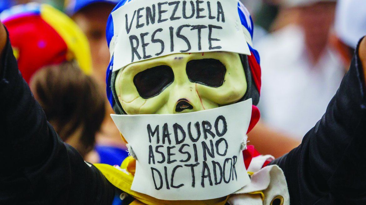 Un manifestante que porta una máscara en alusión al dictador.