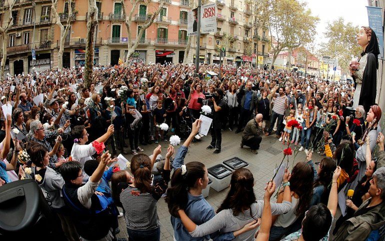 Un grupo de concentrados ante la Escola Pia del barrio de Sant Antoni de Barcelona, junto a unas urnas, durante la jornada de paro, avalada por algunos sindicatos, entidades soberanistas y otras formaciones , en protesta por la actuaci&oacute;n policial durante el refer&eacute;ndum organizado el domingo por la Generalitat a pesar de la suspensi&oacute;n del Tribunal Constitucional. 