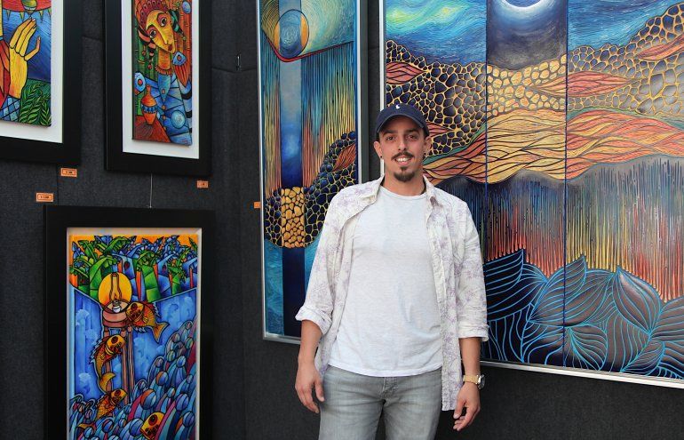 El artista Ra&uacute;l Hern&aacute;ndez posa junto a sus obras. 