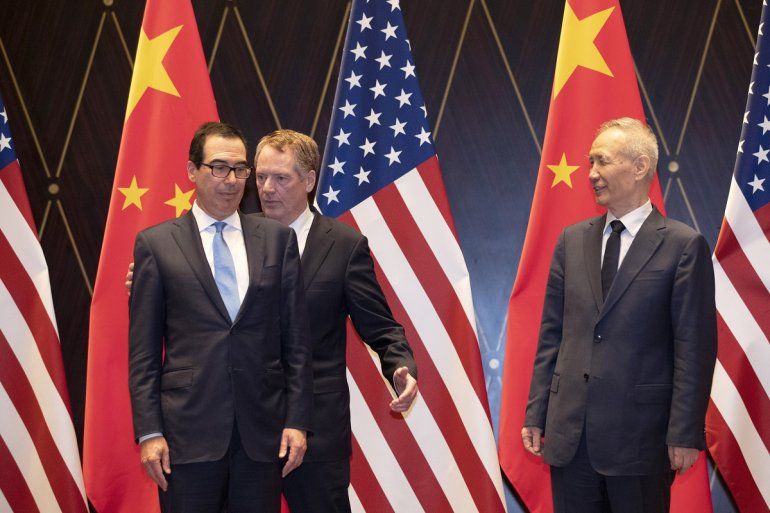 El representante comercial estadounidense Robert Lighthizer, al centro, intercambia posición con el secretario del Tesoro, Steven Mnuchin, mientras a la derecha se encuentra el vicepresidente chino Liu He looks, en el Centro de Conferencias Xijiao, en Shanghái, el 31 de julio de 2019.
