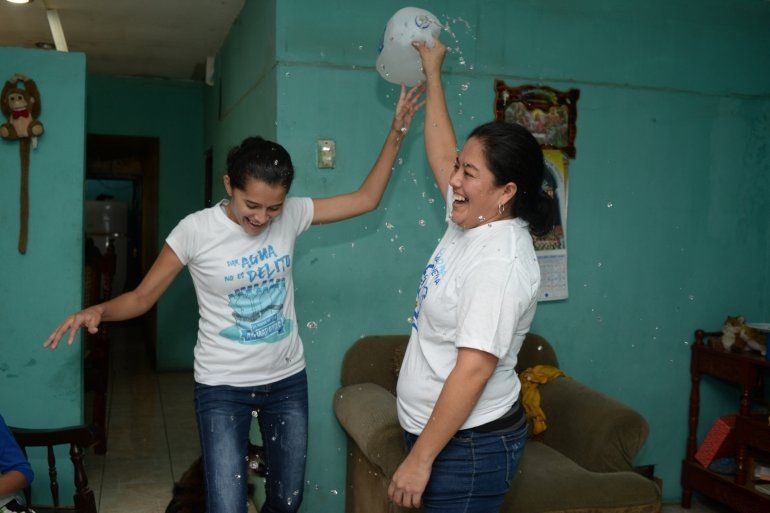 Ivania &Aacute;lvarez sostiene una jarra de agua abierta para celebrar con Neyma Hern&aacute;ndez despu&eacute;s de su liberaci&oacute;n de la prisi&oacute;n en su casa en Managua, Nicaragua, el lunes 30 de diciembre de 2019. 