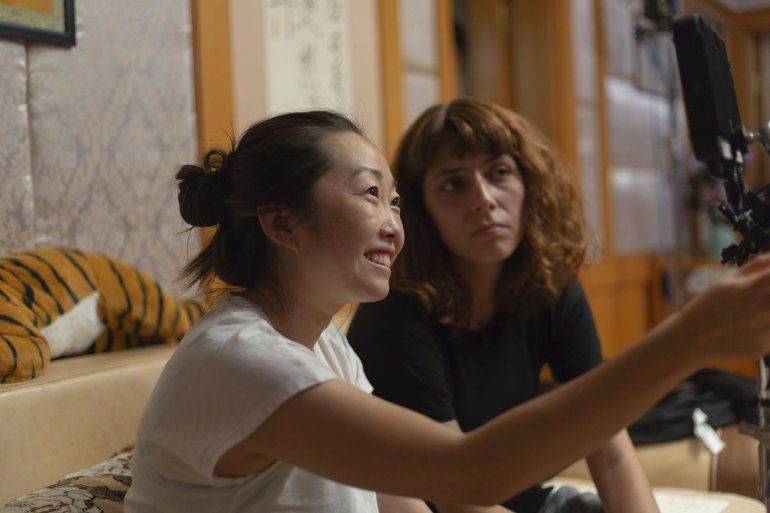 En esta imagen proporcionada por A24 la directora Lulu Wang, izquierda, en el set de "The Farewell". 