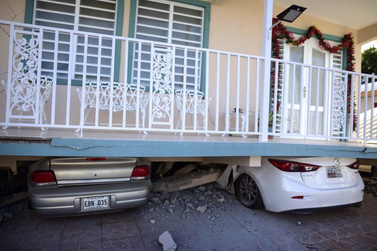 Una vivienda cayó sobre vehículos estacionados después de un terremoto registrado en Guánica, Puerto Rico, el lunes 6 de enero de 2020. Un sismo de magnitud 5,8 remeció Puerto Rico en la madrugada del lunes, provocando pequeños deslaves, cortes en el suministro eléctrico y graves grietas en algunas viviendas.