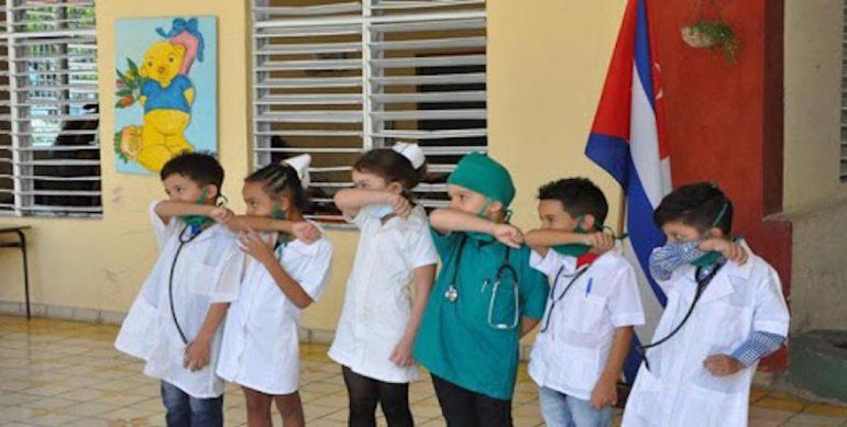 Niños en escuela cubana reciben indicaciones ante el coronavirus. 