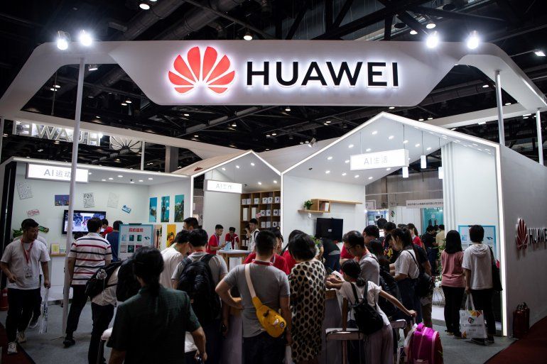 Personas observan dispositivos de la compañía china Huawei durante una feria de tecnología.