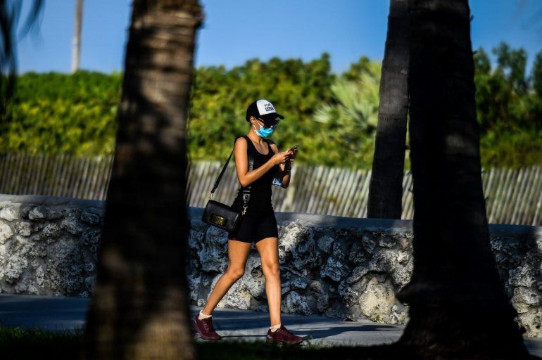 Una mujer usa una m&aacute;scarilla mientras camina por Ocean Drive en South Beach, en Miami, en medio de temores sobre la propagaci&oacute;n del nuevo coronavirus (COVID-19), el 31 de marzo de 2020. 