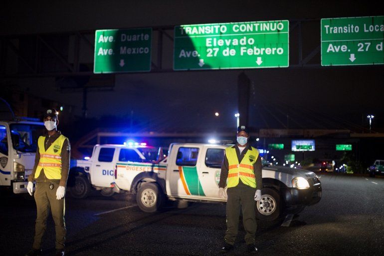 Efectivos de la Polic&iacute;a vigilan el cumplimiento del toque de queda en Santo Domingo, Rep&uacute;blica Dominicana, el 20 de marzo de 2020.