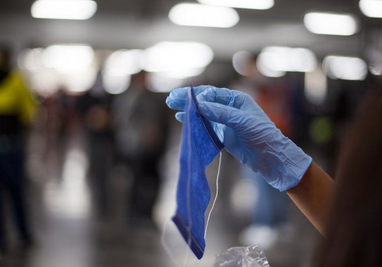 Un empleado sostiene una mascarilla de las utilizadas para protegerse contra el COVID-19 en una estaci&oacute;n del metro en Ciudad de M&eacute;xico, el 17 de abril de 2020.