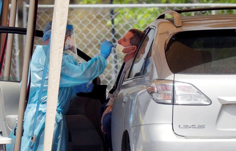 Un trabajador médico realiza a una persona una prueba para detectar el coronavirus en una instalación para automovilistas.