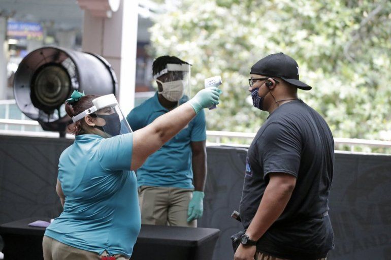 Una empleada de Universal Studios le mide la temperatura a un visitante en la entrada, el mi&eacute;rcoles tres de junio de 2020 en Orlando, Florida. 