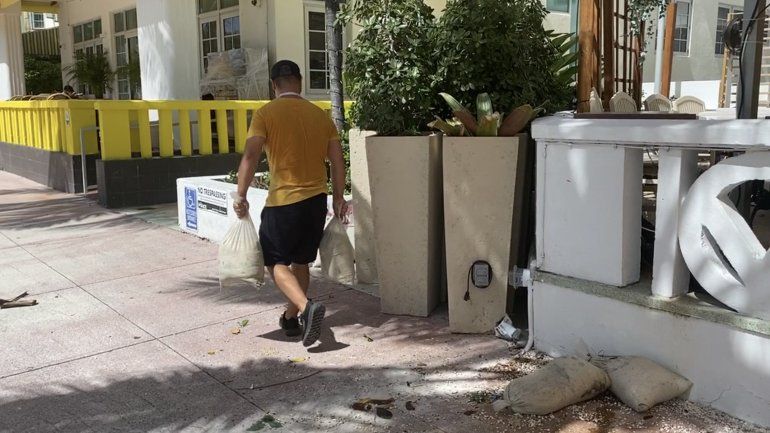 El empleado de un hotel de Miami Beach transporta bolsas con arena que se usan para proteger las puertas ante posibles inundaciones y fuertes vientos.
