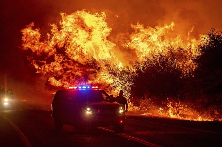 Las flamas de un incendio forestal iluminan la carretera 162 el miércoles 9 de septiembre de 2020, en Oroville, California.