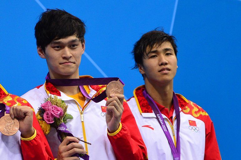 Esta foto de archivo tomada el 31 de julio de 2012 muestra a los chinos Sun Yang (izquierda) y Jiang Haiqi (derecha) posando con sus medallas de bronce en el podio de la final masculina de relevos de estilo libre 4x200m durante el evento de nataci&oacute;n en los <a href=