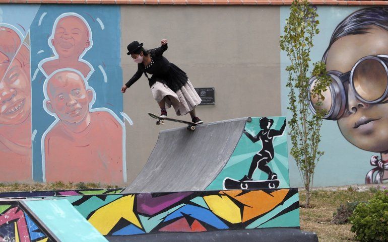 Ayde Choque, con una m&aacute;scara en medio de la pandemia de COVID-19 y vestida como una chola, monta una patineta durante un show de talentos juveniles en La Paz, Bolivia, el mi&eacute;rcoles 30 de septiembre de 2020. 