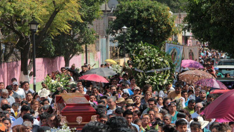Personas participan en el sepelio de dos sacerdotes que fueron asesinados por grupos delictivos en Guerrero.
