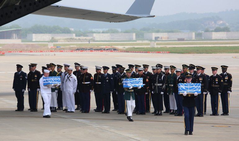 Soldados estadounidenses llevan cajas que contienen los restos de soldados caídos en la Guerra de Corea de 1950-53, este viernes 27 de julio de 2018, en la base aérea de Osan en Pyeongtaek, unos 70 kilómetros al sur de Seúl.