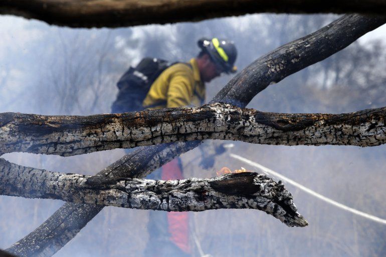 Un bombero del Departamento de Bomberos de St. John Arizona trabaja en un punto caliente en el Cranston Fire en Mountain Center, California.