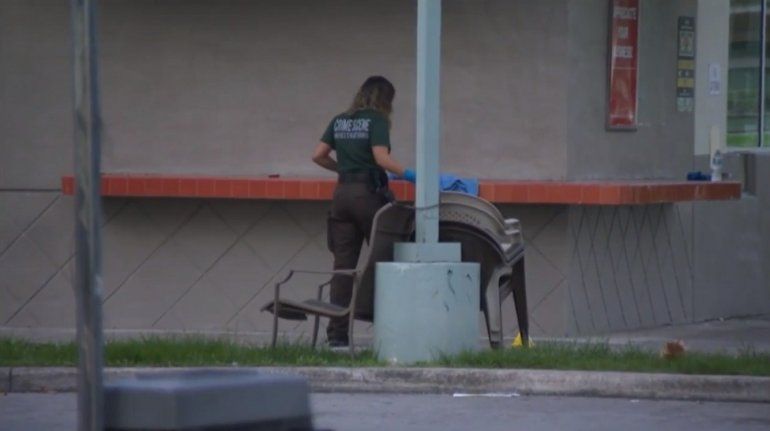 Una oficial de la Policía de Miami-Dade investiga la escena donde un hombre recibió dos disparos en una gasolinera en Homestead.