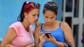 Dos mujeres revisan un teléfono celular en un punto de conexión WiFi en La Habana, Cuba. Dos mujeres revisan un teléfono celular en un punto de conexión WiFi en La Habana, Cuba.