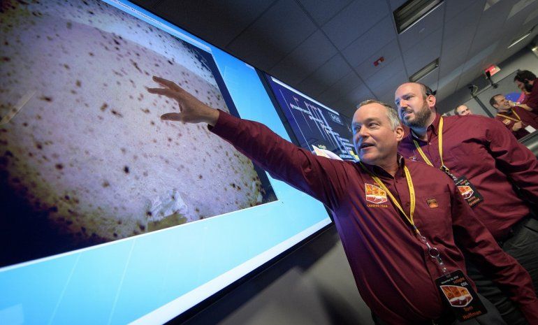 Tom Hoffman (izq.), gerente del Proyecto InSight, junto a Jonny Grinblat (der.), ante la primera imagen llegada de Marte despu&eacute;s del aterrizaje con &eacute;xito del m&oacute;dulo espacial en la superficie del planeta rojo el 26 de noviembre de 2018.