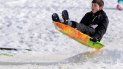 Un niño se desliza en trineo por una pendiente cubierta de nieve. Un niño se desliza en trineo por una pendiente cubierta de nieve.