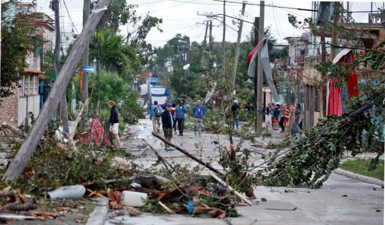 Vecinos caminan por una calle afectada por el paso de un tornado, este lunes, en La Habana (Cuba)