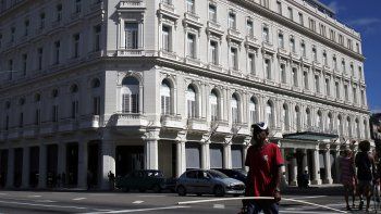 Varias personas caminan junto al Gran Hotel Manzana Kempinski, construido en La Habana.