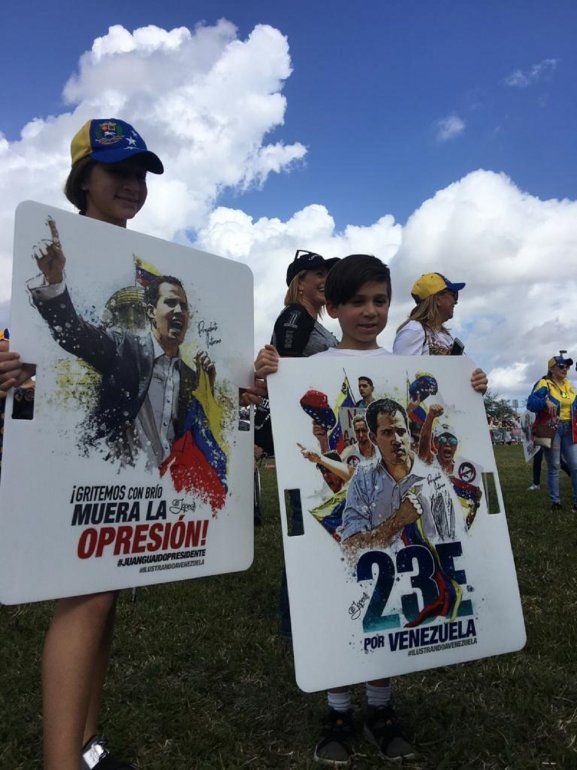 Asistentes con afiches con el rostro de Juan Guaidó , presidente encargado de Venezuela.