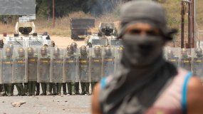 Venezolanos se enfrentan con miembros de la Guardia Nacional Bolivariana este domingo en la frontera entre Pacaraima (Brasil) y Venezuela. 