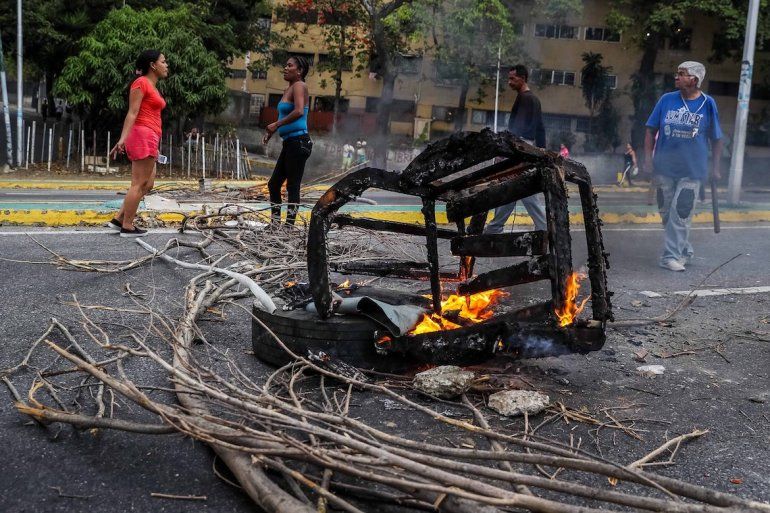 Mujeres cierran la vía en una protesta en el oeste de Caracas por la falta de agua y de electricidad. 