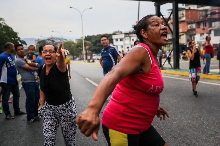 Un grupo de personas protesta por la falta de agua potable y electricidad, en la Avenida Baralt, en el centro de Caracas (Venezuela). 