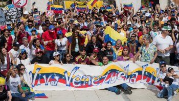 Decenas de personas posan durante una manifestación convocada por la diáspora venezolana en la Plaza Bolívar en Santo Domingo, República Dominicana.
