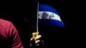 Un joven sostiene una bandera de Nicaragua en forma de protesta contra el gobierno de Daniel Ortega. Un joven sostiene una bandera de Nicaragua en forma de protesta contra el gobierno de Daniel Ortega.