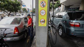 Un trabajador llena con gasolina el tanque de un vehículo en una estación de servicio en Caracas, Venezuela.