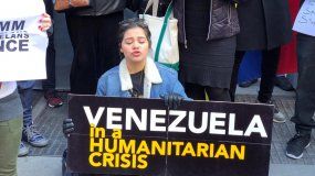 Un grupo de venezolanos sostiene pancartas con frases referentes a la crisis en Venezuela durante una manifestación en Nueva York, EEUU.