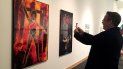Un hombre fotografía una obra de Renèe Cox, la artista jamaicana que se autorretrata convertida en la antiheroina Raje, durante su visita a la muestra Beyond the Cape. Comics and Contemporay Art Un hombre fotografía una obra de Renèe Cox, la artista jamaicana que se autorretrata convertida en la antiheroina Raje, durante su visita a la muestra Beyond the Cape. Comics and Contemporay Art