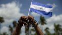 Un hombre con cadenas en las manos y una bandera de Nicaragua participa en una misa por la liberación de los presos políticos. Un hombre con cadenas en las manos y una bandera de Nicaragua participa en una misa por la liberación de los presos políticos.