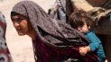 Una mujer transporta a un niño en un campo de refugiados a cargo del Alto Comisionados de las Naciones Unidas para los Refugiados (ACNUR) en Afganistán. Una mujer transporta a un niño en un campo de refugiados a cargo del Alto Comisionados de las Naciones Unidas para los Refugiados (ACNUR) en Afganistán.
