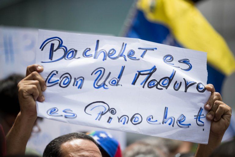 Un manifestante sostiene una pancarta durante una protesta en las inmediaciones de las oficinas del Programa de las Naciones Unidas para el Desarrollo (PNUD), en el marco de la visita a Venezuela de Michelle Bachelet.