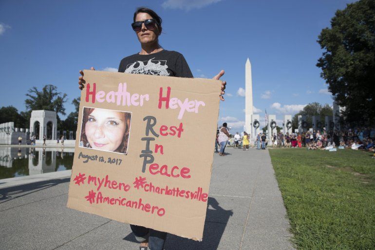 Una mujer sostiene un cartel en honor a Heather Heyer, v&iacute;ctima de la violencia en Charlottesville. 
