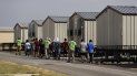 Personal del nuevo centro de detención de migrantes menores de edad de Carrizo Springs, Texas, acompaña a algunos muchachos a las estructuras rodantes que funcionan como habitaciones. Personal del nuevo centro de detención de migrantes menores de edad de Carrizo Springs, Texas, acompaña a algunos muchachos a las estructuras rodantes que funcionan como habitaciones.