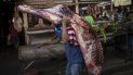 Un vendedor carga con una pieza de carne en una carnicería en un mercado de Maracaibo, Venezuela. Tendrá que venderla pronto ya que, sin refrigeración, los alimentos perecederos se estropean rápidamente. Un vendedor carga con una pieza de carne en una carnicería en un mercado de Maracaibo, Venezuela. Tendrá que venderla pronto ya que, sin refrigeración, los alimentos perecederos se estropean rápidamente.