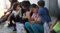Migrantes esperando bajo vigilancia en un centro de inmigración en el Puente Internacional I, mientras un agente de inmigración intenta bloquear la cámara, en Nuevo Laredo, México, el martes 1 de julio de 2019. Migrantes esperando bajo vigilancia en un centro de inmigración en el Puente Internacional I, mientras un agente de inmigración intenta bloquear la cámara, en Nuevo Laredo, México, el martes 1 de julio de 2019.