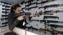 Una joven muestra cómo apuntar un arma, durante una feria de armamentos. Una joven muestra cómo apuntar un arma, durante una feria de armamentos.