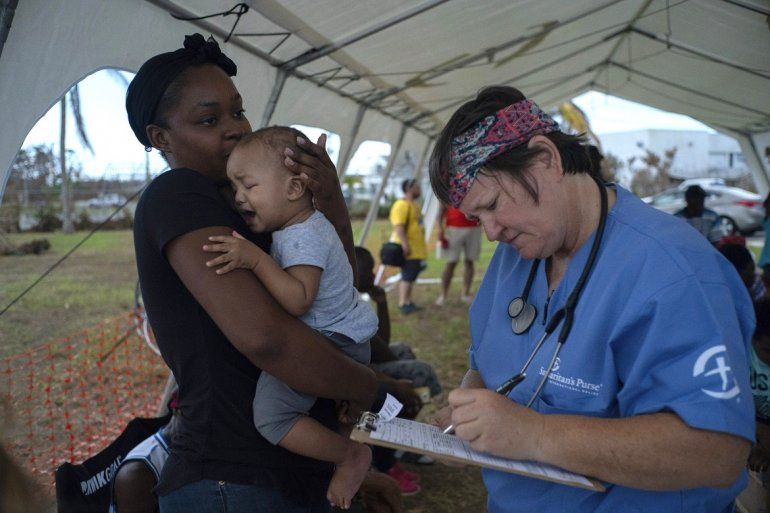 Una mujer sostiene a un bebÃ© para ser atendido en una tienda-hospital por Samaritans Purse tras el huracÃ¡n Dorian en Freeport