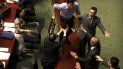 Agentes de seguridad persiguen al legislador prodemocracia Au Nok-hin, en el centro, mientras corre sobre la mesa para perseguir a la directora ejecutiva de Hong Kong, Carrie Lam, que abandona una sesión de preguntas con parlamentarios en el Consejo Legislativo de Hong Kong, el jueves 17 de octubre de 2019. Agentes de seguridad persiguen al legislador prodemocracia Au Nok-hin, en el centro, mientras corre sobre la mesa para perseguir a la directora ejecutiva de Hong Kong, Carrie Lam, que abandona una sesión de preguntas con parlamentarios en el Consejo Legislativo de Hong Kong, el jueves 17 de octubre de 2019.