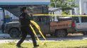 Un oficial de policía de México pone cinta amarilla para asegurar la escena del crimen. Un oficial de policía de México pone cinta amarilla para asegurar la escena del crimen.