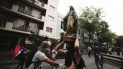 Un manifestante enmascarado carga una imagen religiosa que removió de una iglesia para añadirla a una barricada en Santiago de Chile, el viernes 8 de noviembre de 2019. Un manifestante enmascarado carga una imagen religiosa que removió de una iglesia para añadirla a una barricada en Santiago de Chile, el viernes 8 de noviembre de 2019.