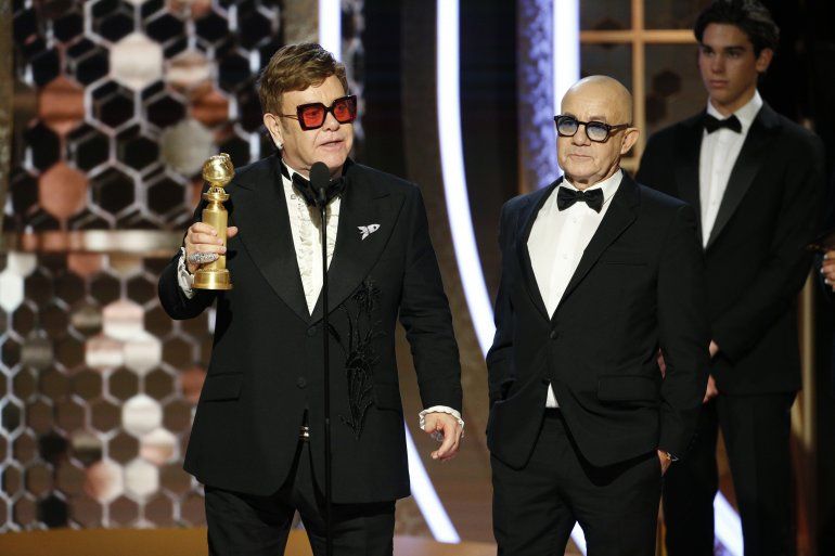 En esta imagen difundida por NBC, Elton John, a la izquierda, y Bernie Taupin reciben el Globo de Oro a la mejor canción original por "I