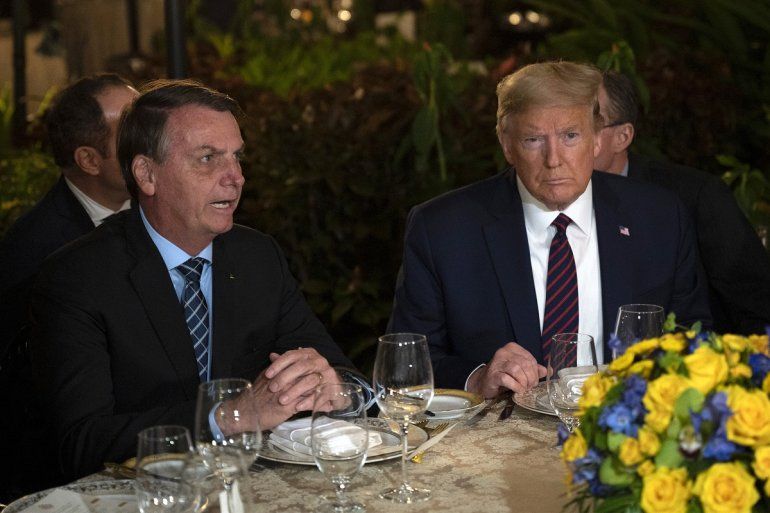 El presidente Donald Trump escucha a su homólogo brasileño, Jair Bolsonaro (izq), dufrante una cena en Mar-a-Lago, Palm Beach, Florida, el sábado 7 de marzo de 2020.